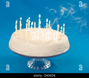 Gâteau d'anniversaire avec de la fumée provenant de bougies soufflées Banque D'Images