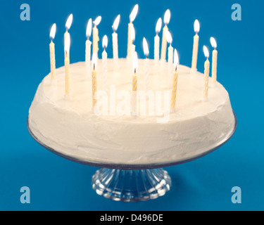 Birthday cake with burning candles on blue background Banque D'Images