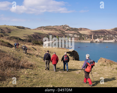 Randonneurs marche sur Isle of Anglesey côte avec vue sur baie à Porth abandonnés Wen briqueteries. Anglesey, au nord du Pays de Galles, Royaume-Uni Banque D'Images