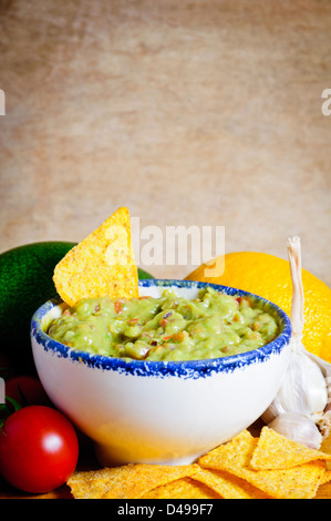 Avocado guacamole trempette avec ingrédients sur un fond de bois Banque D'Images