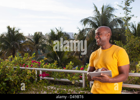 Man using digital tablet in garden Banque D'Images