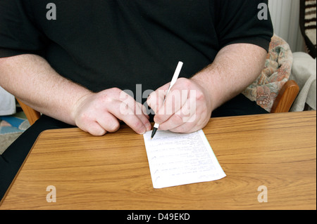 L'homme de remplir formulaire de demande de renouvellement de prescription / ordonnances Banque D'Images