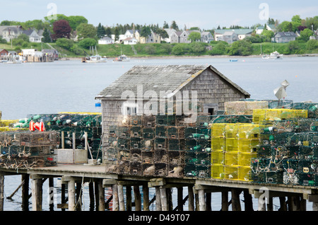 Une cabane à pêche sur l'île de Beals, Maine est muré dans par des pieux de casiers à homard. La ville de Jonesport est visible à travers la baie. Banque D'Images