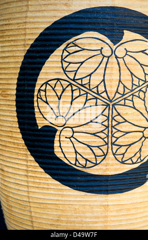 A traditional lantern bearing a triple hollyhock family crest symbolising legacy and unity