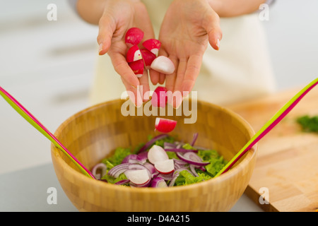 Gros plan sur l'ajout de ménagère en radis salade de légumes Banque D'Images