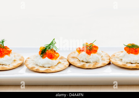 Apéritif caviar avec fromage de chèvre et les craquelins on white plate Banque D'Images