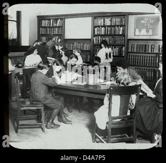 Cette photographie de 1913 montre la Bibliothèque pour les aveugles lors d'une visite de Boy Scouts, mettant en vedette des enfants aveugles avec des rubans de cheveux, illustrant le rôle de la bibliothèque dans l'éducation et l'accessibilité. Banque D'Images