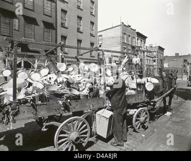 Cette photographie montre un magasin d'étain itinérant à Brooklyn, New York, en 1936. L'image capture la vie dans la rue et les entreprises mobiles, telles que le magasin d'étain, pendant les années 1930, mettant en valeur la communauté dynamique de Brooklyn. Banque D'Images