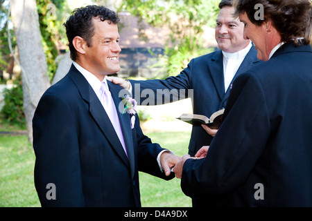 Couple Gay, anneaux d'échanges au cours de leur cérémonie de mariage. Banque D'Images