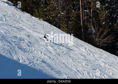 Skieur de montagne en descendant du flanc d'une montagne Banque D'Images