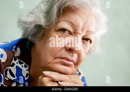 Les gens et les émotions, portrait of senior hispanic woman déprimé avec des cheveux blancs, s'appuyant avec les mains sur le menton Banque D'Images