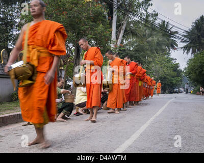 Luang Prabang, Laos. 11 mars 2013. Les moines bouddhistes, recueillir des aumônes pendant le tak bat à Luang Prabang. Le ''Tak Bat'' est un rituel quotidien dans la plupart des du Laos (et d'autres pays bouddhiste theravada comme la Thaïlande et le Cambodge). Moines quittent leurs temples à l'aube et marche silencieusement à travers les rues et les gens mettent du riz et autres produits alimentaires dans leurs bols d'aumône. Luang Prabang, dans le nord du Laos, est particulièrement bien connu pour le matin ''tak bat'' en raison du grand nombre de temples et de moines dans la ville Crédit : ZUMA Press, Inc. / Alamy Live News Banque D'Images