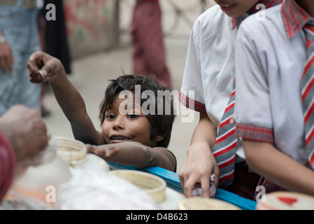 Un enfant mendiant achète des bonbons à un vendeur de rue à Kolkata, Inde Banque D'Images