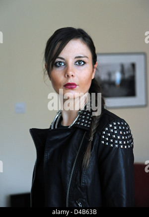 Jeune femme de 20 ans portant un blouson de cuir cloutés dans le rock chick style fashion avec cheveux balayés retour Banque D'Images