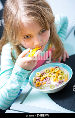 Young Girl eating cornflakes du bol Banque D'Images