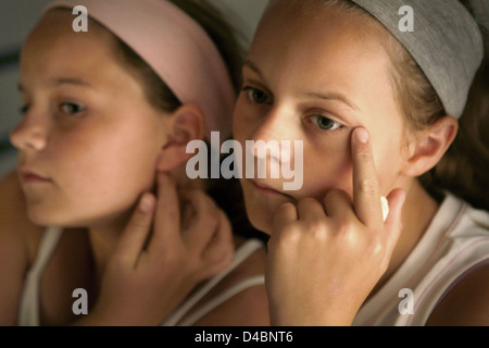 Deux filles contrôler leurs visages pour les taches Banque D'Images