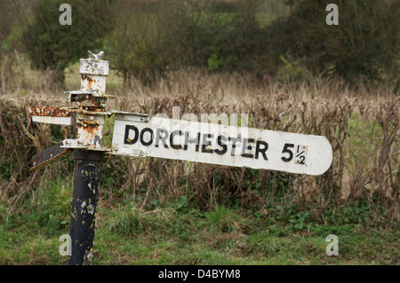 English panneau routier. "Dorchester 5 ½ milles". Une vieille ruine fingerpost à côté d'un chemin de campagne en milieu rural Dorset, Angleterre, Royaume-Uni. Banque D'Images