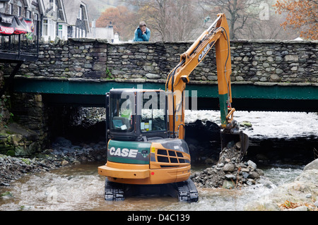 Un type JCB digger travaillant dans une rivière de Penrith, le Lake District, en Angleterre Banque D'Images