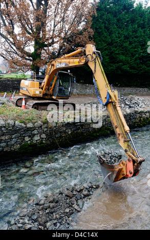 Un type JCB digger travaillant dans une rivière de Penrith, le Lake District, en Angleterre Banque D'Images