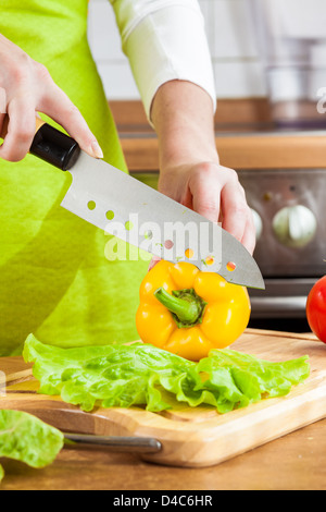 Woman's hands cutting poivron frais sur la cuisine Banque D'Images