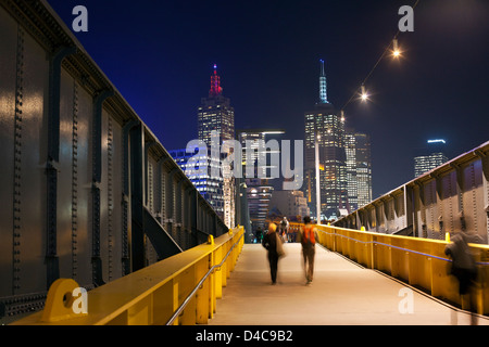 Piétons sur chemin Sandridge Bridge at night with city skyline en arrière-plan. Melbourne, Victoria, Australie Banque D'Images