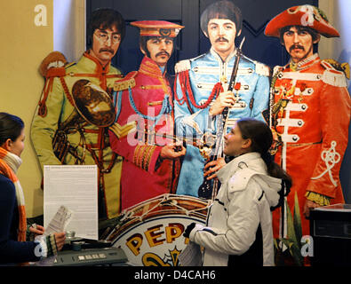 Les visiteurs se tenir en face de la grande image de couverture de l'enregistrement 1967 'Sgt. Pepper's Lonely Hearts Club Band", montrant les musiciens légendaires John Lennon, Paul Mc Cartney, George Harrison et Ringo Starr, de Liverpool à la musée des Beatles à Halle (Saale), Allemagne, 03 janvier 2008. Le musée possède plus de 20 000 pièces, dont les rares enregistrements, autographes, affiches, photos Banque D'Images