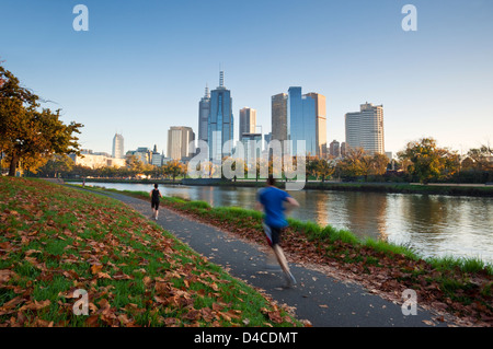 Les coureurs sur les banques du fleuve Yarra avec ville en arrière-plan. Melbourne, Victoria, Australie Banque D'Images