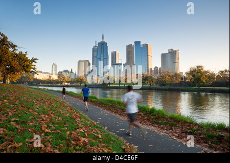 Jogger sur les rives de la rivière Yarra avec ville en arrière-plan. Melbourne, Victoria, Australie Banque D'Images