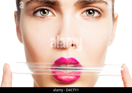 Portrait of woman holding test tube de laboratoire dans ses lèvres isolated on white Banque D'Images