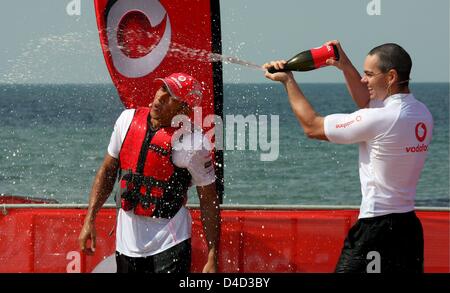 Australian V8 Supercars conducteur Craig Lowndes (R) sprays champagne sur la formule britannique Lewis Hamilton, pilote de McLaren Mercedes après un événement kayak de plage à Melbourne, Australie, 12 mars 2008. L'Australian Grand Prix de Formule 1 aura lieu au Circuit d'Albert Park à Melbourne le dimanche 16 mars. Photo : ROLAND WEIHRAUCH Banque D'Images