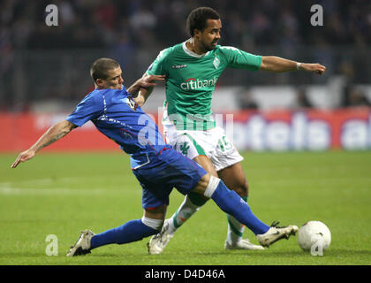 Nacho Novo de Glasgow (L) convoite la la balle avec le Werder Patrick Owomoyela au cours de la deuxième ronde de la coupe de l'UEFA jambe seize match Werder Brême vs Glasgow Rangers à Brême, Allemagne, le 13 mars 2008. Photo : Carmen Jaspersen Banque D'Images