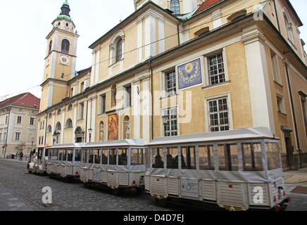 Le petit train qui passe devant la cathédrale de St ou Saint Nicholas Ljubljana Slovénie Europe Banque D'Images