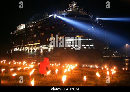 Navire de croisière de luxe AIDAbella est reçu avec des torches en feu à l'entrée d'un port maritime lock à Emden, Allemagne, 27 mars 2008. Avec l'arrivée du navire à Emden un 11 heures transfert par l'intermédiaire de la rivière Ems relativement petite a pris fin. Le nouveau bateau de croisière qui sera remis au transporteur AIDA Cruises le 14 avril 2008 est de 252 mètres de long et 32,2 mètres de large. C'est le second navire Banque D'Images