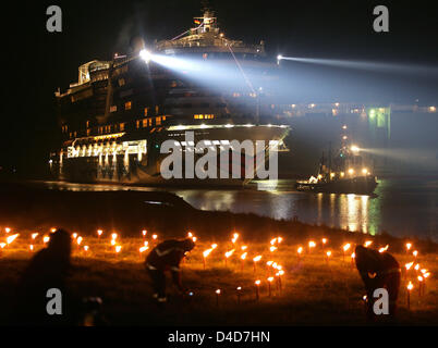 Navire de croisière de luxe AIDAbella est reçu avec des torches en feu à l'entrée d'un port maritime lock à Emden, Allemagne, 27 mars 2008. Avec l'arrivée du navire à Emden un 11 heures transfert par l'intermédiaire de la rivière Ems relativement petite a pris fin. Le nouveau bateau de croisière qui sera remis au transporteur AIDA Cruises le 14 avril 2008 est de 252 mètres de long et 32,2 mètres de large. C'est le second navire Banque D'Images