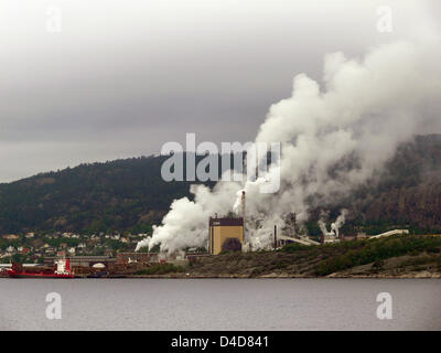 Une plante produit de la fumée de ses cheminées à l'horizon, la Norvège, le 27 juin 2007. Photo : Hinrich Baesemann Banque D'Images