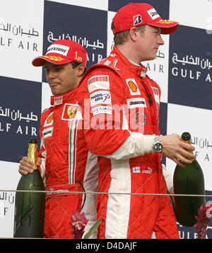 Pilote de Formule 1 brésilien Felipe Massa de la Scuderia Ferrari (L) célèbre remportant le Grand Prix de Bahreïn de Formule 1 devant son coéquipier finlandais Kimi Raikkonen (R) au circuit de Sakhir, près de Manama, Bahreïn, 06 avril 2008. Photo : Jens Buettner Banque D'Images