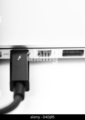 LONDON-jan.01 : photo studio d'un câble thunderbolt lié à un ordinateur portable, le 18 janvier, 2013 à Londres, Royaume-Uni. Thunderbolt d'Intel est une nouvelle solution de connectivité qui offrent une vitesse de transfert 10 fois plus rapide par rapport à la solution de connexion esata et plus. Banque D'Images