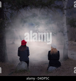 Deux filles assis sur des pierres dans une forêt