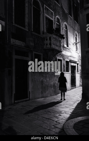 Femme debout seul la nuit dans une rue de Venise Banque D'Images