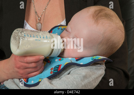 Baby Boy étant alimenté par sa bouteille jeune mère de six mois Banque D'Images