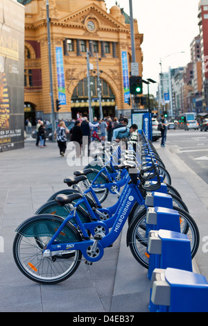 Partager vélo des vélos à la place de la fédération avec la gare de Flinders Street en arrière-plan. Melbourne, Victoria, Australie Banque D'Images