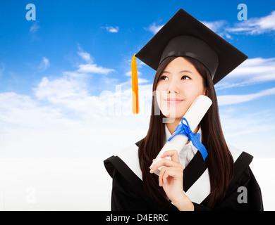 Diplômé smiling woman Holding Degré avec fond de nuage Banque D'Images