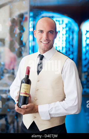 Waiter holding bouteille de vin au restaurant Banque D'Images