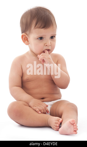 Funny baby est assis sur le plancher et garde doigt de la souris. Banque D'Images