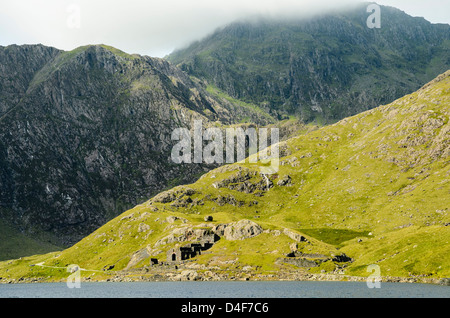 Ruines de Britannia Mines de cuivre par Llyn Llydaw Snowdonia, avec le pic de Snowdon (Yr Wyddfa) dans le nuage derrière Banque D'Images