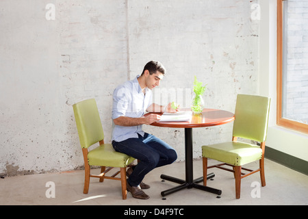 Businessman reading at table in office Banque D'Images