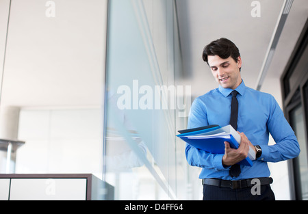 Businessman using digital tablet in office corridor Banque D'Images