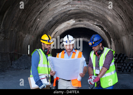 Les travailleurs et businessman with blueprints in tunnel Banque D'Images