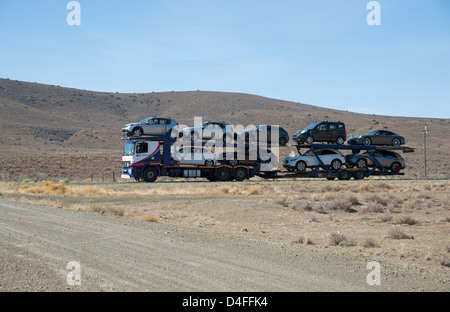 Voiture avec un plein chargement de véhicules circulant sur la N1 à un Lainsburg ville du Karoo, Afrique du Sud Banque D'Images