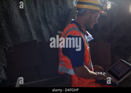 Worker using laptop in tunnel Banque D'Images